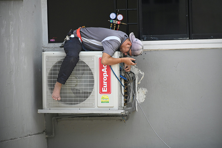 man fixing AC